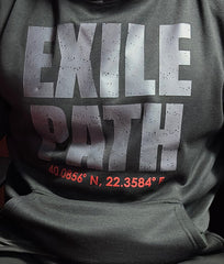 Person wearing a dark hoodie with 'EXILE PATH' text sitting on a red chair.