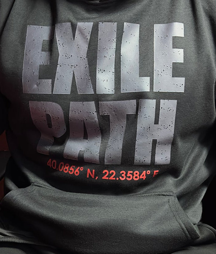 Person wearing a dark hoodie with 'EXILE PATH' text sitting on a red chair.